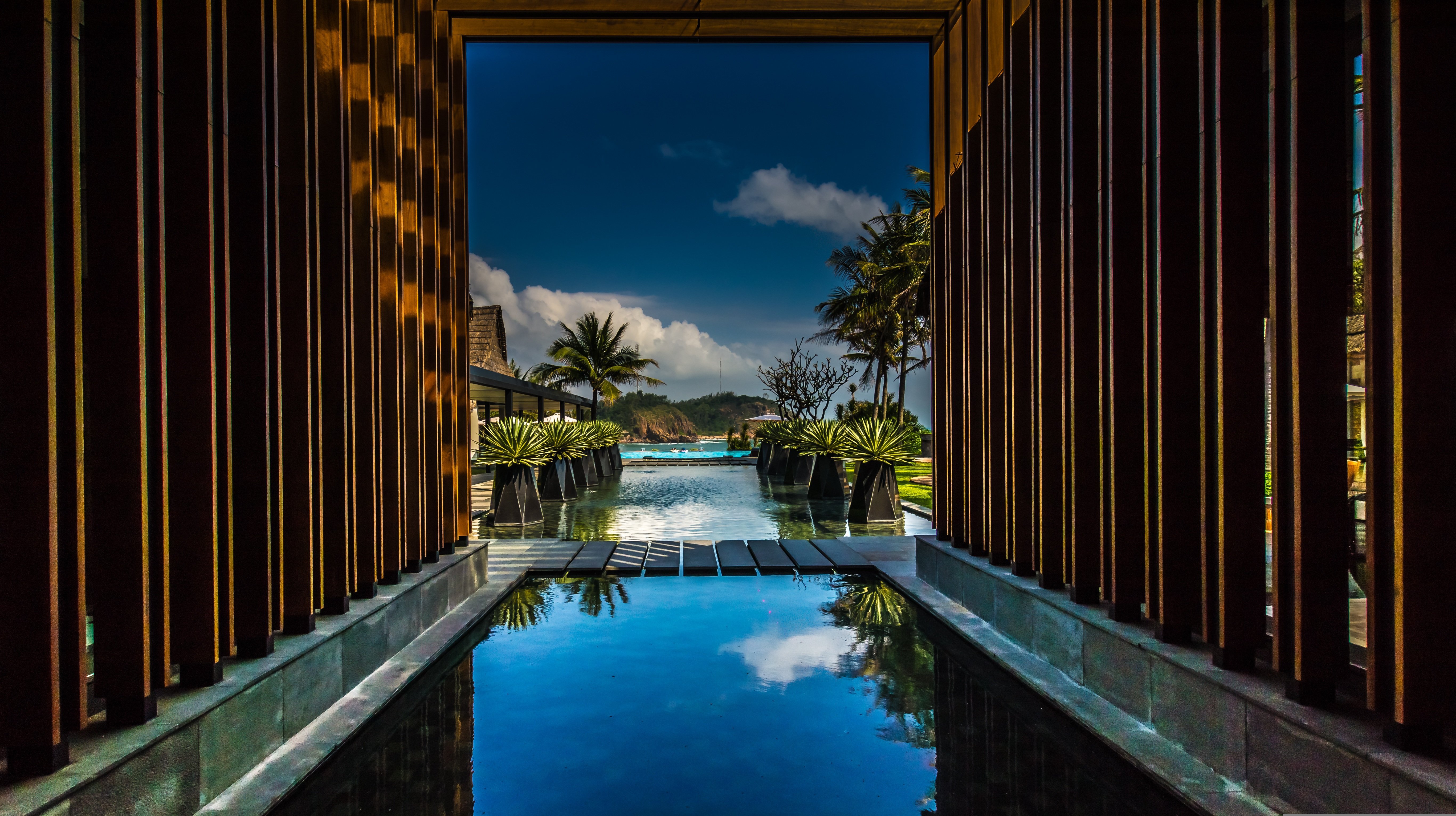 Luxury tropical resort entrance with reflection pool and ocean view